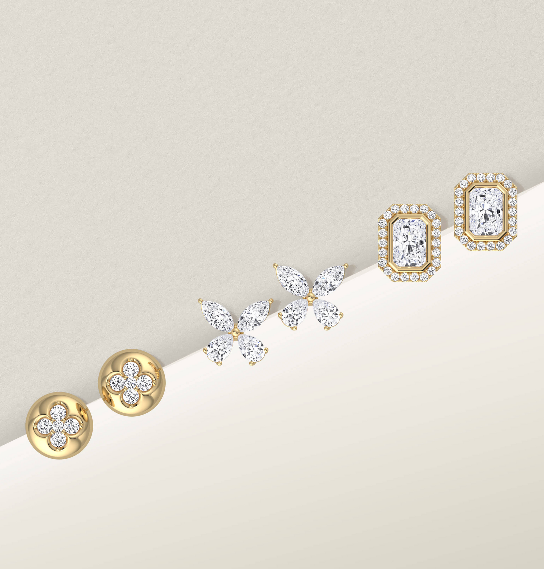 Set of gold and diamond earrings on a light background